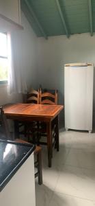 a kitchen with a wooden table and chairs and a refrigerator at Casa do paraiso in Palhoça