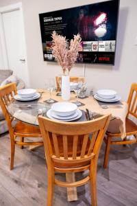 a dining room table with chairs and a tv at Charming 1-Bedroom Just 1 Mile from Morley Town Center in Leeds in Pudsey