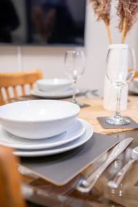 uma mesa com pratos e copos de vinho em Charming 1-Bedroom Just 1 Mile from Morley Town Center in Leeds em Pudsey