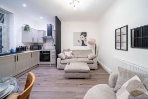 a living room with two chairs and a kitchen at Charming 1-Bedroom Just 1 Mile from Morley Town Center in Leeds in Pudsey