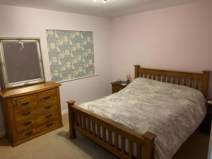 a bedroom with a bed and a dresser and a mirror at Immaculate central 4-Bed townhouse in Beverley in Beverley