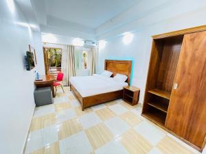 a bedroom with a bed and a table and a desk at Pulickal Heights Hotel in Entebbe