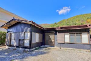 une maison noire avec une montagne en arrière-plan dans l'établissement Lake Kawaguchiko, Vacation House, 3LDK BBQ OK !! 竹之家-Takenoya- Perfect for famiry and group travel !!, à Fujikawaguchiko