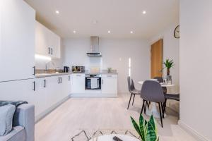 a kitchen and living room with a couch and a table at Modern Flat in Leeds by PureStay Short Stays in Leeds