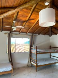 a room with two bunk beds and a ceiling with wooden beams at Chalés em Ilhabela in Ilhabela