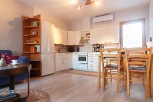 a kitchen with white cabinets and a table and chairs at Saimaan Kodikas in Savonlinna