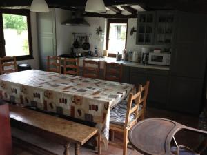una cocina con una mesa y sillas y una cocina con una mesa y una mesa en DOMAINE DU BOIS L'ABBE, en Épaignes