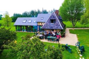 un grupo de personas sentadas fuera de una casa en DOMAINE DU BOIS L'ABBE, en Épaignes