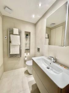 een witte badkamer met een wastafel en een toilet bij Drury Lane Residences in Londen