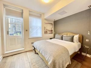 um quarto com uma cama grande e uma janela em Drury Lane Residences em Londres