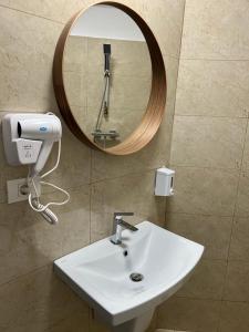 bagno con lavandino bianco e specchio di La Vila Maria a Bucarest