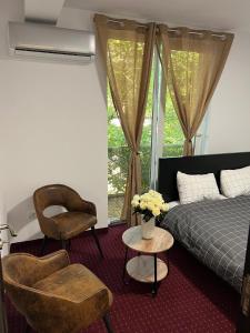 una camera con letto, sedia e tavolo di La Vila Maria a Bucarest