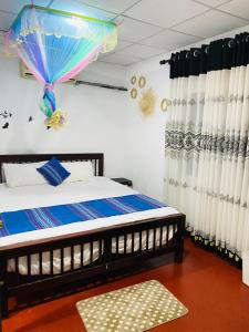 a bedroom with a bed with an umbrella on the wall at CINNAMON LAKE VILLA in Habaraduwa