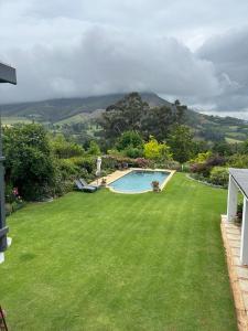 une grande cour avec une piscine sur gazon dans l'établissement Camberley Wines - Luxury Accommodation, à Stellenbosch