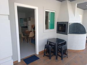 a living room with a table and a fireplace at Residencial Brisa do Mar 2 in Bombinhas