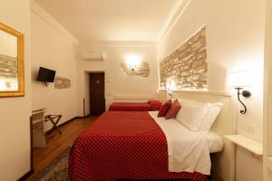 Habitación de hotel con 2 camas con sábanas rojas y blancas en Hotel Pax, en Asís