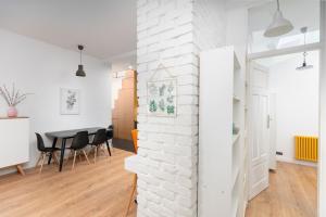 a white brick wall in a living room with a table at Apartment with a roof terrace in Poznań
