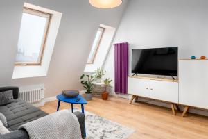 a living room with a tv and a couch at Apartment with a roof terrace in Poznań
