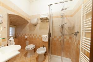 a bathroom with a shower and a toilet and a sink at Hotel Pax in Assisi
