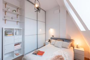 a bedroom with a bed with white walls and an attic at Apartment with a roof terrace in Poznań
