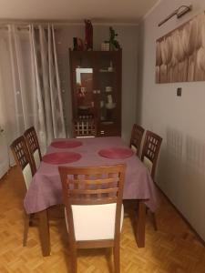 a dining room table with chairs and a purple table cloth at KWATERY PRACOWNICZE in Środa Wielkopolska