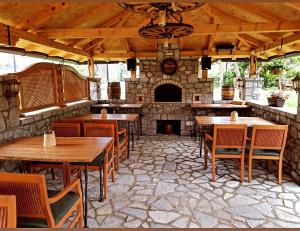 a restaurant with wooden tables and chairs and a stone fireplace at Holiday bungalows with pool in Plav