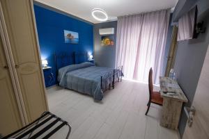 a bedroom with blue walls and a bed and a table at Room 112 Oltremare in Bagheria +10 photos