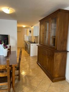 una cocina con mesa y un gran armario de madera en Casa Vacanze Padru, en Padru