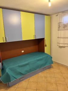 a bed in a room with yellow and green walls at Casa Vacanze Padru in Padru