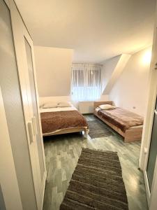 een kleine slaapkamer met 2 bedden en een raam bij La Mama in Pietroasa