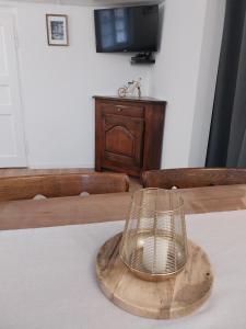 una gabbia sopra un piatto di legno su un tavolo di La Petite Maison de la Petite Vallée a Rott