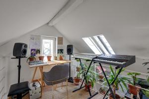 a music room with a keyboard and a desk with plants at Pretty Parisian Penthouse in Paris