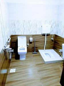 a bathroom with a toilet and a sink at Galaxy Inn Guest House in Karachi