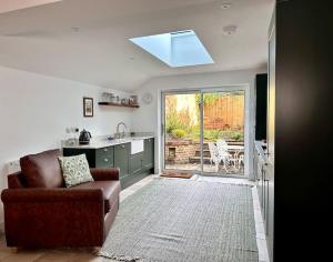 a living room with a couch and a kitchen at Cathedral Views Period Townhouse w/ Free Parking in Salisbury