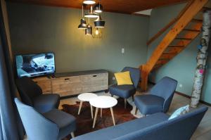 - un salon avec des chaises, une télévision et une table dans l'établissement Maison du Lac 14, à Vielsalm