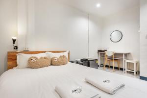 a bedroom with a bed with two stuffed owls on it at Sloth Hostel Don Mueang in Ban Don Muang (1)