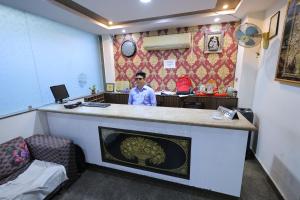 a man sitting at a bar in a room at Hotel Orchid & Banquet in Agra