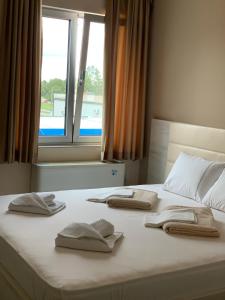 a bed with three pillows on it with a window at Kristal Garni Hotel in Novi Sad