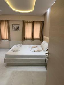 a bedroom with a bed with white sheets and pillows at Kristal Garni Hotel in Novi Sad