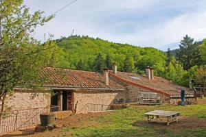 an old stone house with a picnic table in front of it at Auberge de Lascours, gîte d'étape pleine nature. in Ceilhes-et-Rocozels