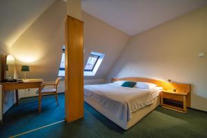 Schlafzimmer mit einem Bett, einem Schreibtisch und einem Tisch in der Unterkunft Hotel Gromada Toruń in Toruń