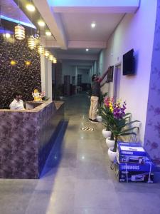 a man is standing in a lobby with a counter at Hotel Vrindavan Ratnagiri in Ratnagiri