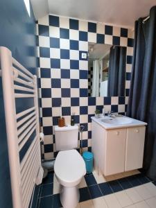 een badkamer met een toilet, een wastafel en een spiegel bij Charmant studio proche du château in Versailles