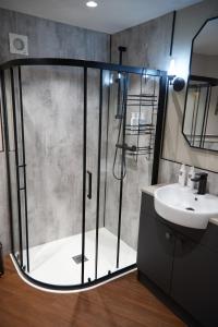 uma casa de banho com um chuveiro e um lavatório. em Cumbria Holiday Apartment Ainstable em Ainstable