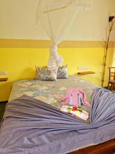a bed with a doll laying on it w obiekcie Nature Paradise Guesthouse w mieście Wayikkal