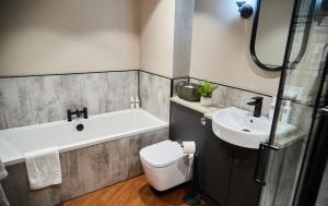 a bathroom with a tub and a sink and a toilet at Cumbria Holiday Apartment Ainstable in Ainstable