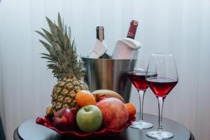 a bowl of fruit and two glasses of wine at Concept Royal Edirne in Edirne