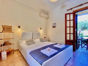 a bedroom with a large white bed with two towels on it at Pangea Corfu Villa in Sidari +43 photos