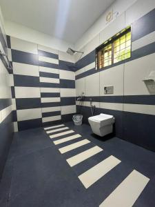Mount court munnar في مونار: حمام به جدران مخططة باللون الأزرق والأبيض ومرحاض