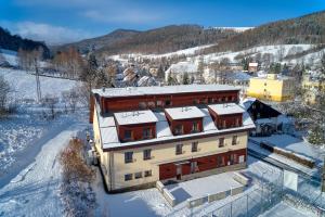 an aerial view of a building with snow covered roofs at Hotel Toč in Lipova Lazne